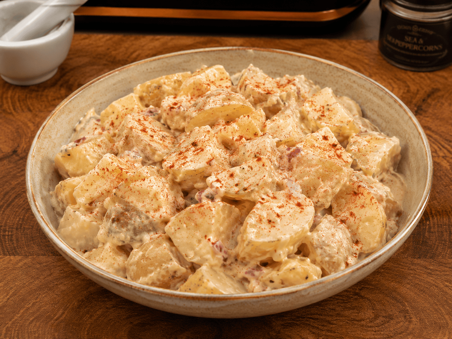 punchy potato salad with creamy dressing, diced red onion, gherkins and smoked paprika